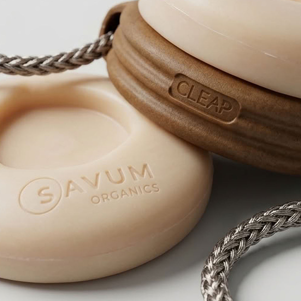 Gros plan sur la gravure SAVUM ORGANICS d'un savon solide clipsé dans sa poignée CLEAP en bois