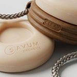 Gros plan sur la gravure SAVUM ORGANICS d'un savon solide clipsé dans sa poignée CLEAP en bois