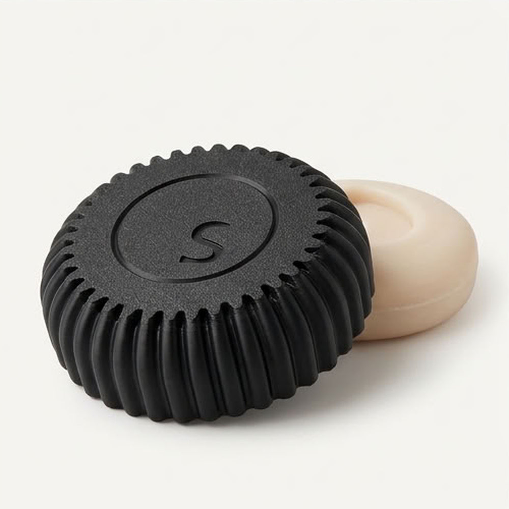 Le porte-savon CLEAP noir et un savon solide SAVUM sur fond blanc